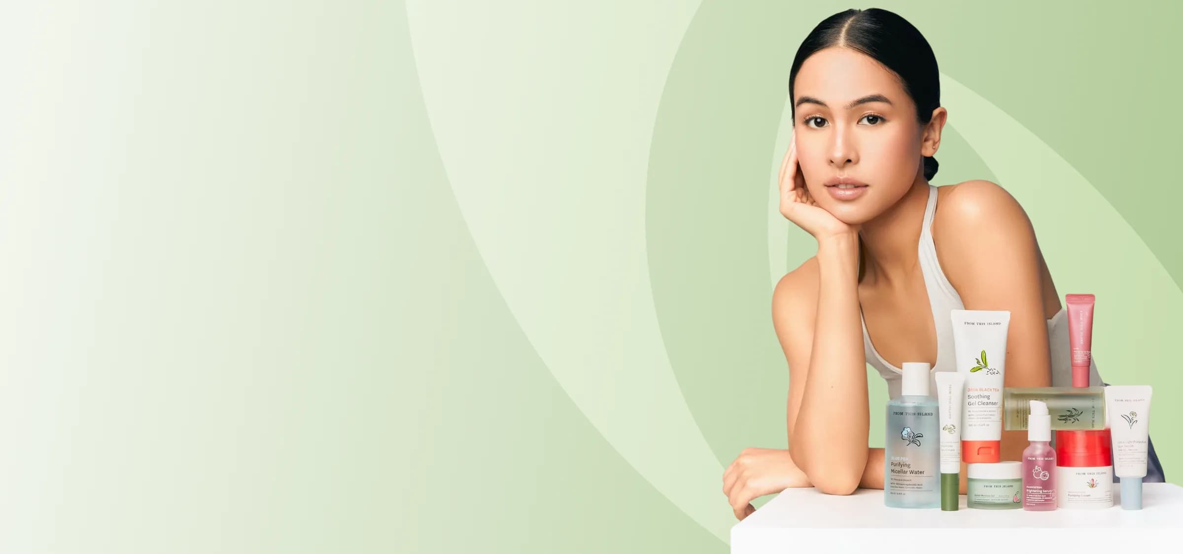 Woman resting her chin on her hand beside a lineup of new K-beauty skincare products